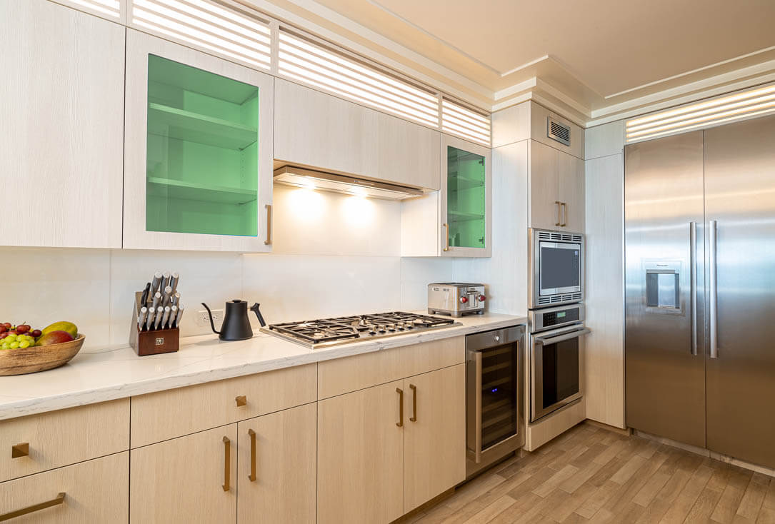 Kitchen with counter top seating, sink, stove, oven, refrigerator.