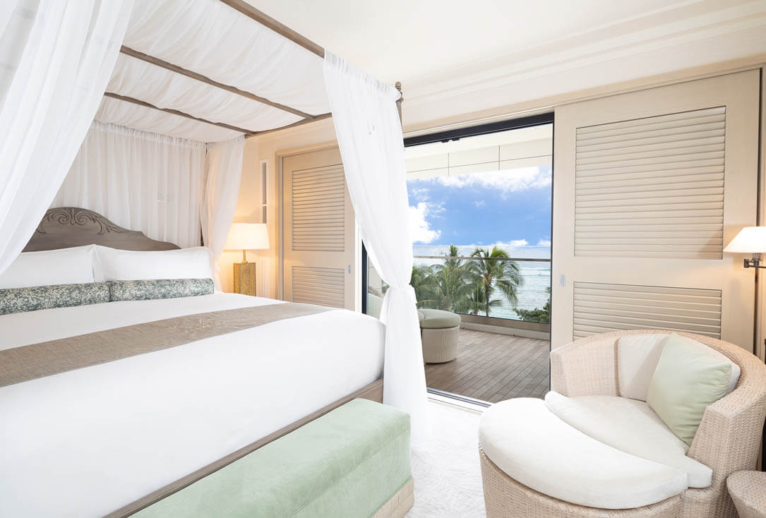 Canopy style bed, lamps, lounge seat, balcony, and view of ocean.