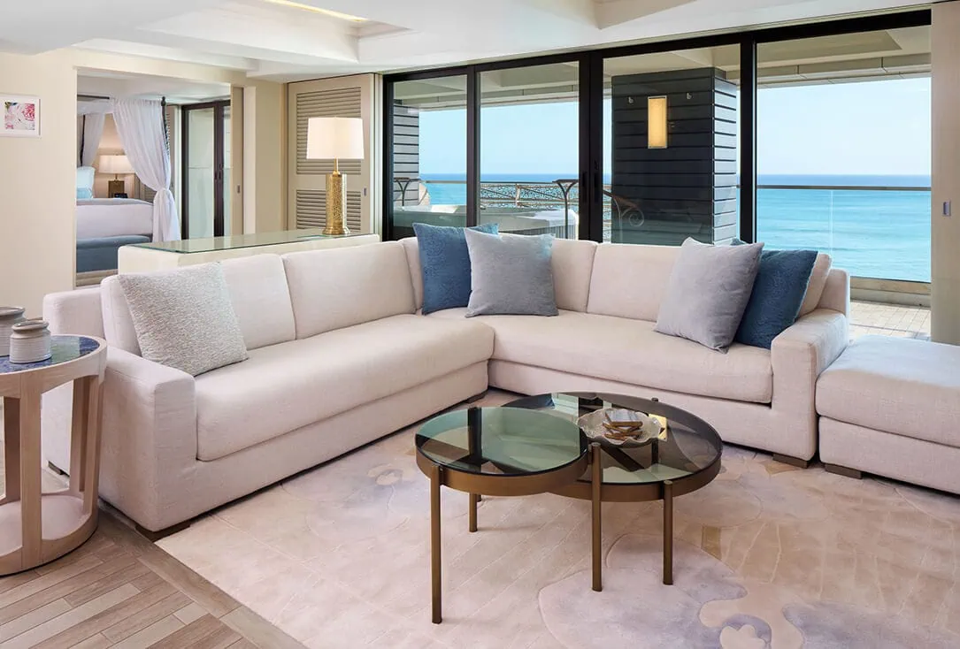 Living room with a sectional couch, coffee table, and balcony with ocean views.